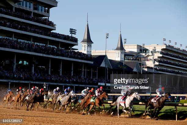 Medina Spirit, ridden by jockey John Velazquez, leads the field around the first during the 147th running of the Kentucky Derby at Churchill Downs on...