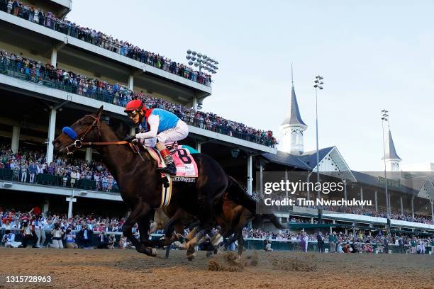 Medina Spirit, ridden by jockey John Velazquez, crosses the finish line to win the 147th running of the Kentucky Derby ahead of Mandaloun, ridden by...