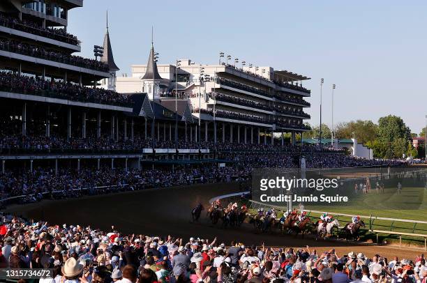 Medina Spirit, ridden by jockey John Velazquez, leads the field around the first turn during the 147th running of the Kentucky Derby at Churchill...