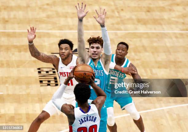 LaMelo Ball of the Charlotte Hornets defends a pass by Josh Jackson of the Detroit Pistons during the second quarter of their game at Spectrum Center...
