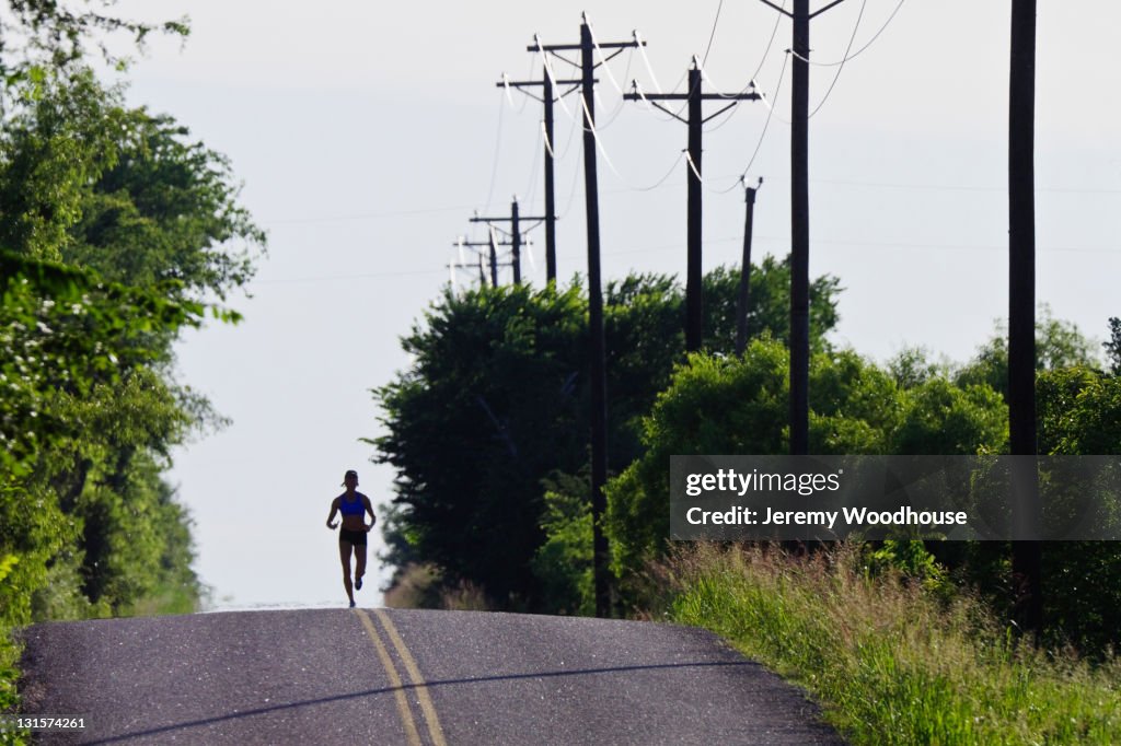 Caucasian runner training on remote road