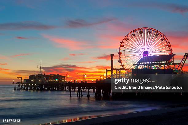 amusement park on waterfront at night - santa monica los ángeles stock pictures, royalty-free photos & images