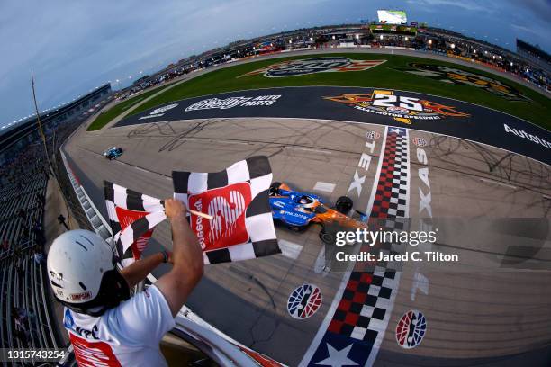 Scott Dixon of New Zealand, driver of the PNC Bank Chip Ganassi Racing Honda, takes the checkered flag to win the NTT IndyCar Series Genesys 300 at...