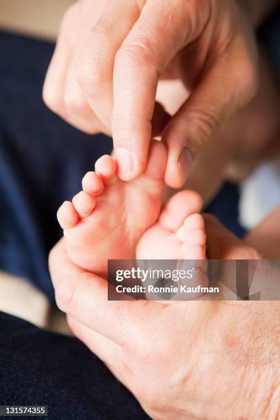 caucasian grandfather playing with grandson's feet - tickling feet stock pictures, royalty-free photos & images