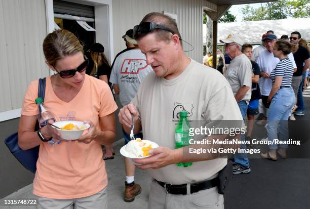 Jen and Rich Fanaro of Exeter Township about to enjoy their peaches and ice cream after surviving the long line. The Oley Fire Company held its...