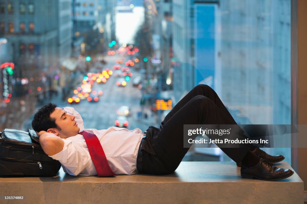 Caucasian businessman sleeping on bench