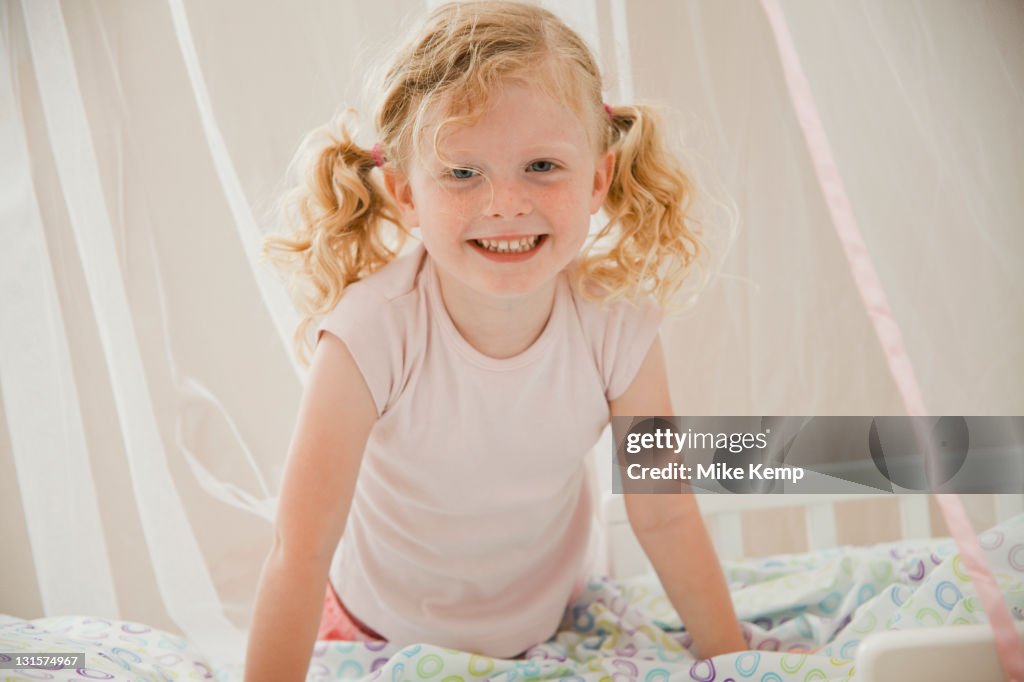 Sorridente caucasiana menina na cama