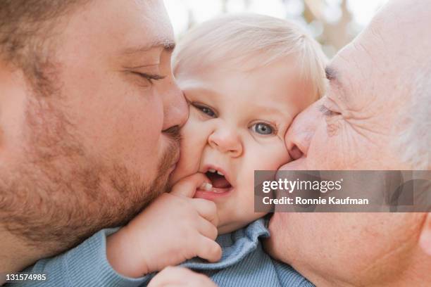 caucasian grandfather and father kissing son - cheek kiss stock pictures, royalty-free photos & images