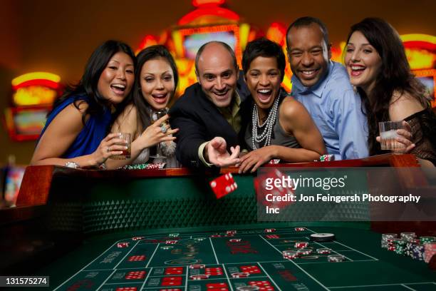 heureux amis à jouer à la table de craps au casino - jeu de dés photos et images de collection