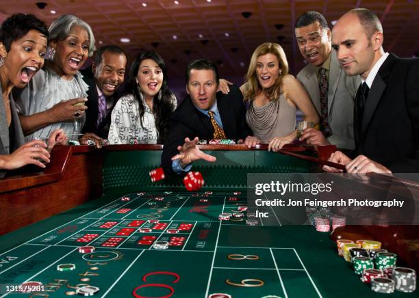 excited friends gambling at craps table in casino - casino dice stock pictures, royalty-free photos & images