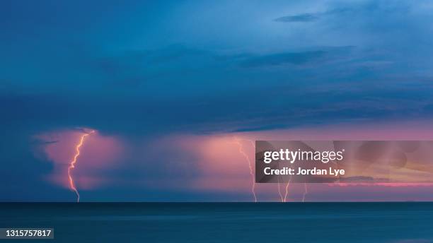 lightning strike by the sea - monzón fotografías e imágenes de stock