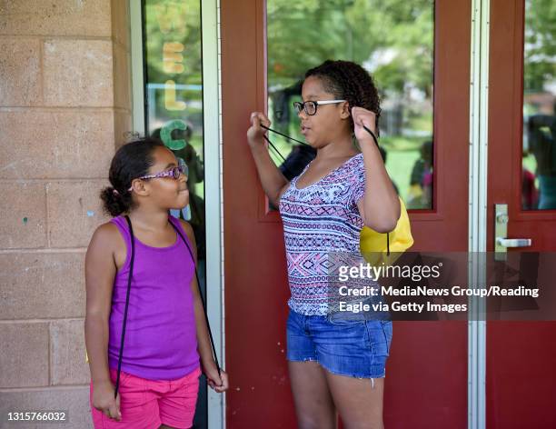 Sisters Amaya left, and Tiannah Veneable talk together after receiving backpacks during Peace on the Streets Back to School Drive at the 11th and...