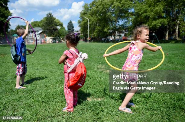 Siblings Christopher Iliana and Sophia Gonzalez play together after receiving backpacks during Peace on the Streets Back to School Drive at the 11th...
