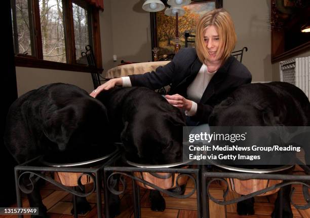 Photo Ryan McFadden 200700761 Pet Food concerns; Carrie Stuart Minahan of S. Heidelberg twp with her and her husbands black labs, from left are Bexar...
