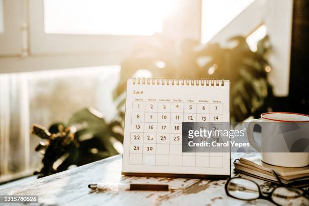june calendar, note pads and coffee cup. - week schedule stock pictures, royalty-free photos & images