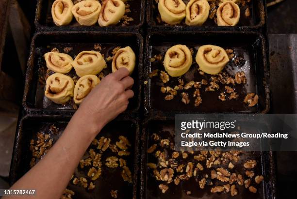 Rolled dough is placed in the baking pans pre-filled with syrup and walnuts.Plain 'N Fancy Donut Shop in Schuylkill Haven bakes their wares fresh...