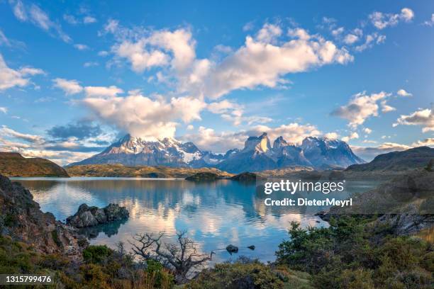 blauw meer op een besneeuwde bergenachtergrond en bewolkte hemel torres del paine - maart stockfoto's en -beelden