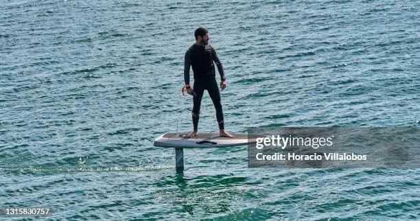 Surfer sails on a Waydoo Flyer ONE electric powered board in the Bay of Cascais on the day it ends the state of emergency during the COVID-19...