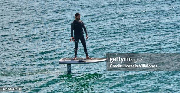 Surfer sails on a Waydoo Flyer ONE electric powered board in the Bay of Cascais on the day it ends the state of emergency during the COVID-19...