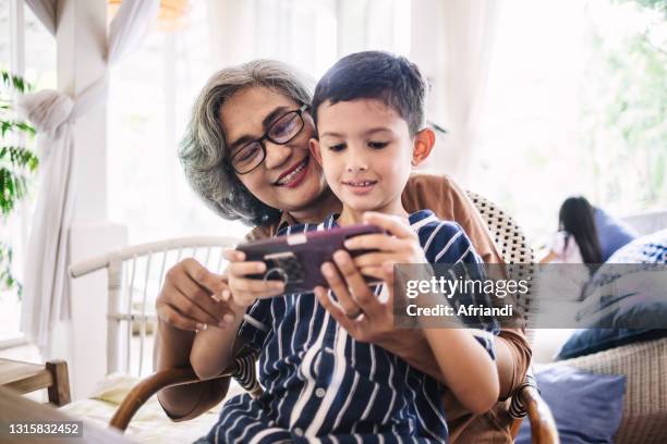 grandmother and grandson playing games - kids fun indonesia stock pictures, royalty-free photos & images