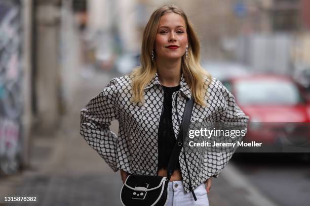 Melanie Kroll wearing black and white Furla bag, white Tommy Hilfiger jeans, black and white Longchamp jacket and black top on April 29, 2021 in...