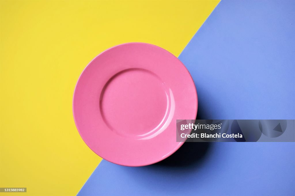 Pink plate on blue and yellow background