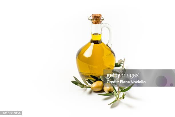 olive oil in a bottle, green olives and olive tree branches isolated on white background - olives stockfoto's en -beelden