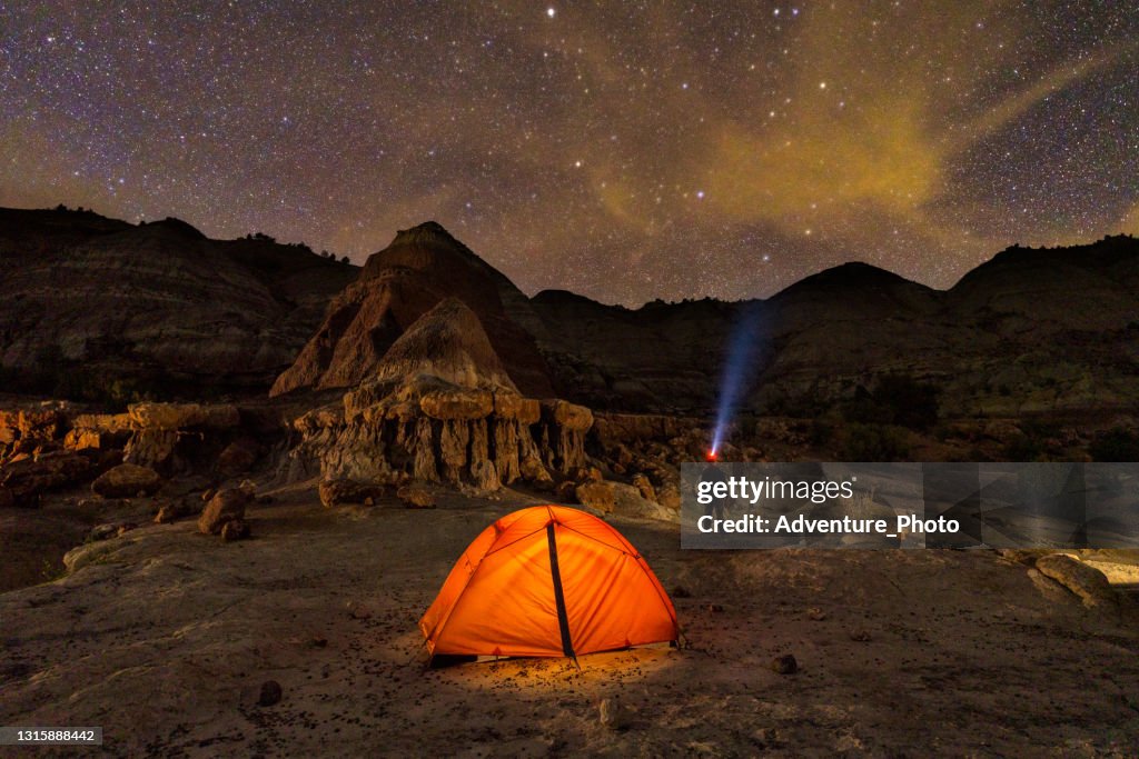 Tent Glowing Amongst Red Rock Hoodoo Formations at Night