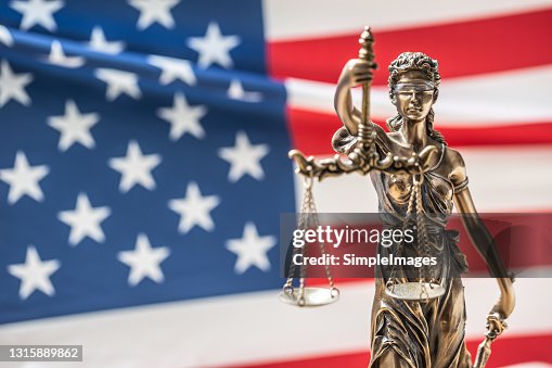 The statue of justice, goddess of justice in front of american flag. The statue of justice, goddess of justice in front of american flag.