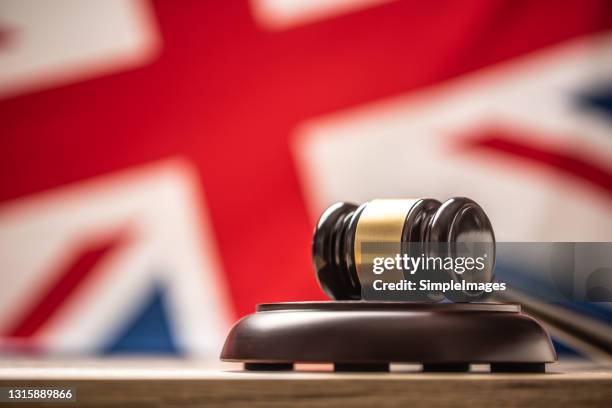 judges wooden hammer in front uk flag. - sentencing stock pictures, royalty-free photos & images