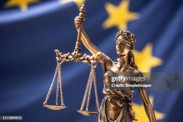 the statue of justice, goddess of justice in front of eu flag. - true crime stock pictures, royalty-free photos & images