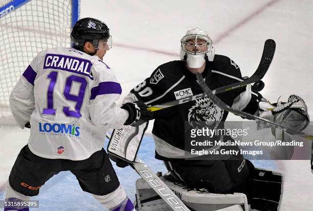 Reading forward Justin Crandall swings at a puck over Manchester goalie Jonah Imoo .Reading Royals lose 4-2 to the Manchester Monarchs in an ECHL...