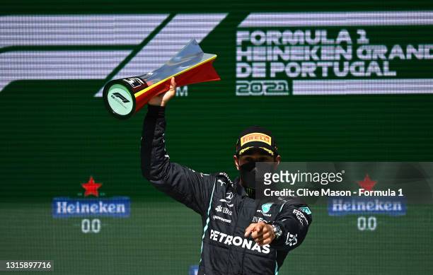 Race winner Lewis Hamilton of Great Britain and Mercedes GP celebrates with his trophy on the podium during the F1 Grand Prix of Portugal at...