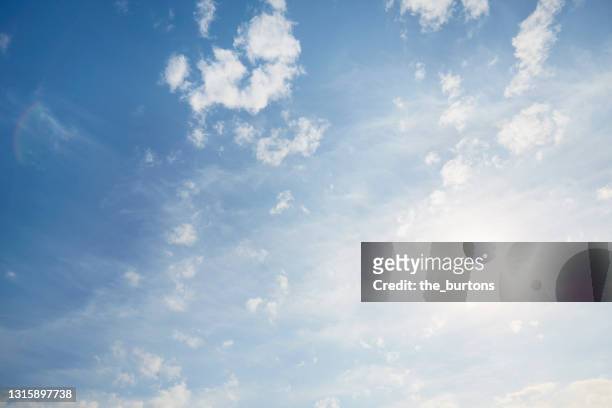 full frame shot of blue sky and clouds against sun, abstract background - cloud sky stock-fotos und bilder