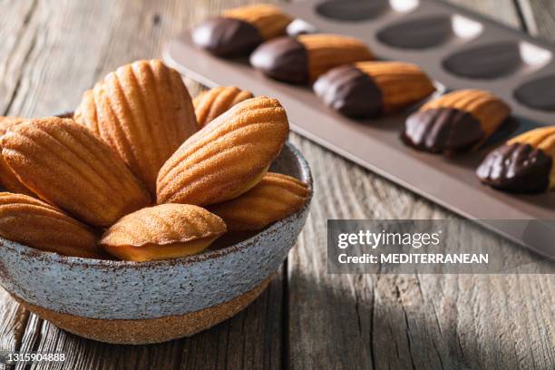 madeleines homemade in a bowl freshly baked on rustic wood - madeleine sponge cake stock pictures, royalty-free photos & images