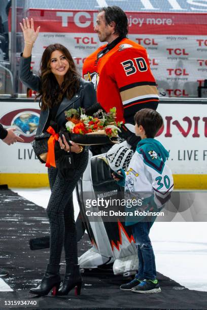 Actress Noureen DeWulf waves to the arena as she leaves the ice with her husband, goaltender Ryan Miller of the Anaheim Ducks, and son Bodhi Miller...