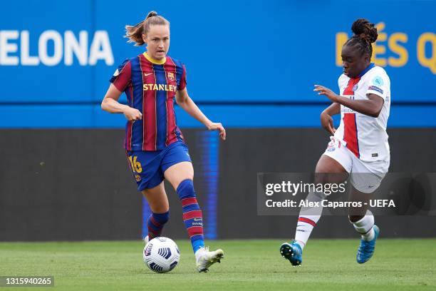 Caroline Graham Hansen of FC Barcelona runs with the ball under pressure from Sandy Baltimore of Paris Saint-Germain during the UEFA Women's...