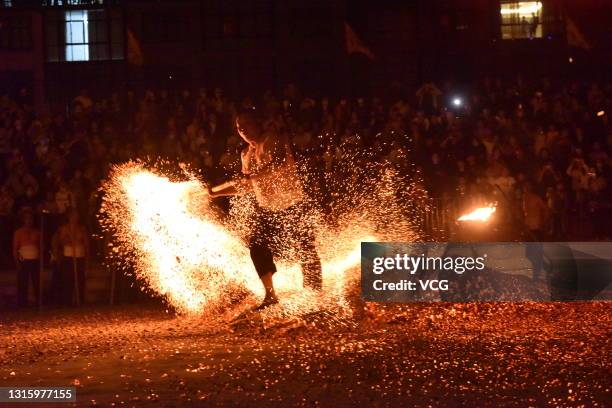 Barefooted man walks through burning charcoal as he performs the traditional ritual called 'Lianhuo', or 'fire walking', on the second day of the May...