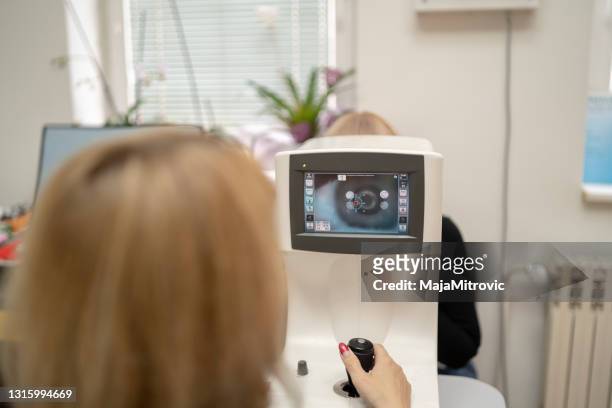 de arts van de oogarts in het laboratorium van de onderzoek opticien met vrouwelijke patiënt. oogzorg - eye exam stockfoto's en -beelden