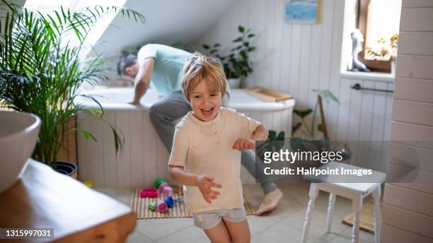 father with small son in bathroom at home, preparing for a bath. - brothers bathroom stock-fotos und bilder