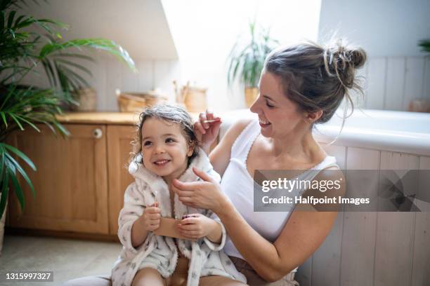 mother with small daughter in bathroom at home, cleaning ears after bath. - kid bath mother stock-fotos und bilder