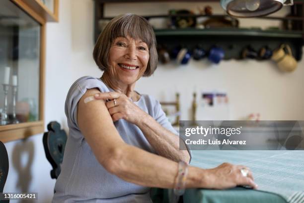 senior woman feeling proud after getting covid-19 vaccine - vaccin photos et images de collection