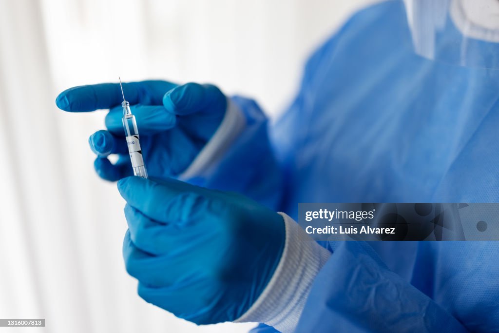 Healthcare worker in PPE with a vaccination injection