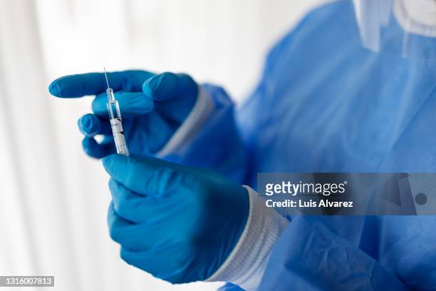 healthcare worker in ppe with a vaccination injection - vaccination imagens e fotografias de stock