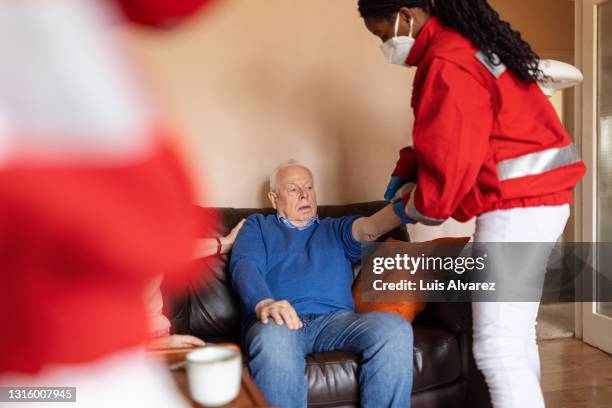 doctor measuring blood pressure of senior man at home - blood pressure gauge isolated stock pictures, royalty-free photos & images