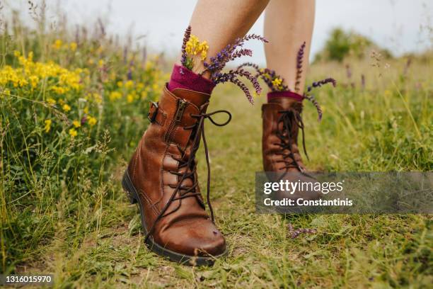 walking in boots full of flowers wildflowers - leather boots stock pictures, royalty-free photos & images