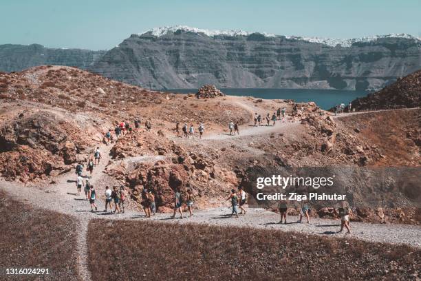 crowds of tourist exploring volcanic island - santorini volcano stock pictures, royalty-free photos & images