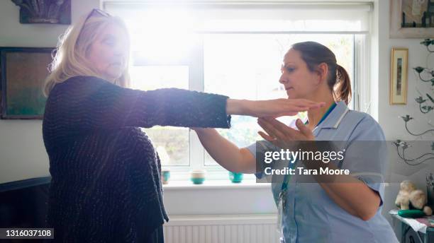 nurse doing home visit with senior patient - infirmière et maison photos et images de collection