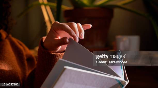 close up of hands with book - sfogliare libro foto e immagini stock