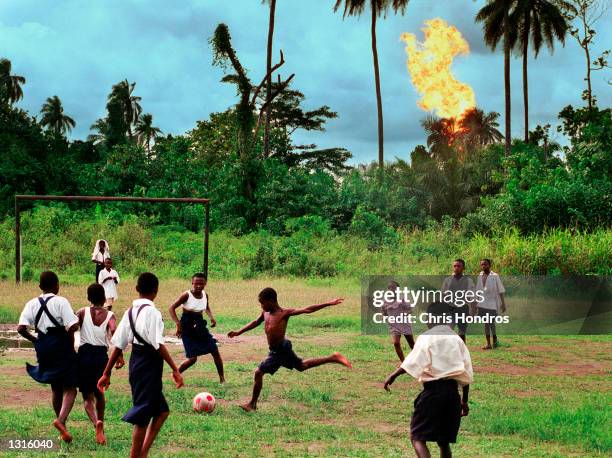Children in the Nigerian village of Akaraolu play soccer at recess while the nearby Oshie gas flare roars on. No one under the age of 30 in the...